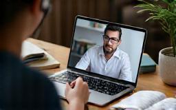 Employee studying online with a mentor on screen